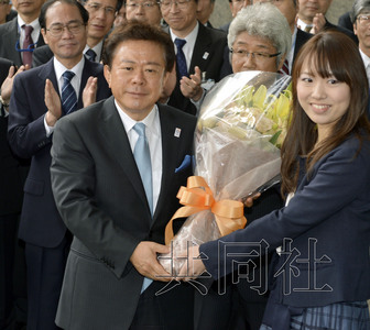 12月18日，高票當選東京都新知事的豬瀨直樹正式到任。圖為豬瀨從政府職員手中接過花束。(共同社)